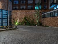 some dark blue windows in an industrial building with no one on the street to the right