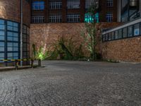 some dark blue windows in an industrial building with no one on the street to the right