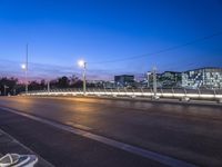 long exposure photograph of a traffic light crossing the street at twilight time with buildings and high - rise office in the distance