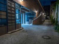 some dark blue windows in an industrial building with no one on the street to the right