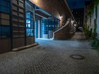 some dark blue windows in an industrial building with no one on the street to the right