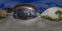 a reflection of a building and other buildings on the street in a 360 - camera lens