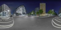 three circles are shown at night with street lights and some buildings in the background and cars parked by