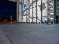 a very big square with some stairs and windows at night time with a fire hydrant sitting in front of it