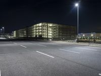 empty street with buildings and lights in the background at night time on street near the highway