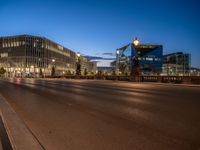 the city skyline is at night from the street level with traffic and pedestrians walking on it