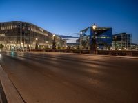 the city skyline is at night from the street level with traffic and pedestrians walking on it