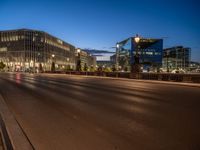 the city skyline is at night from the street level with traffic and pedestrians walking on it