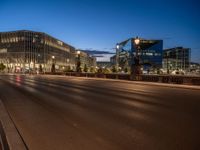 the city skyline is at night from the street level with traffic and pedestrians walking on it