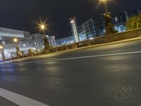 a road with lights shines in the dark over an empty street at night near a city