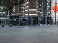 a very big square with some stairs and windows at night time with a fire hydrant sitting in front of it