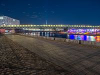 the walkway is next to the river with several boats on it in front of buildings