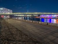 the walkway is next to the river with several boats on it in front of buildings