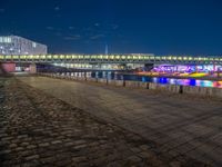 the walkway is next to the river with several boats on it in front of buildings