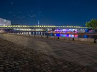 the walkway is next to the river with several boats on it in front of buildings