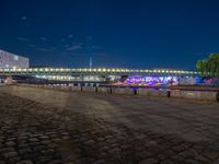the walkway is next to the river with several boats on it in front of buildings