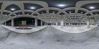 a panorama view of the inside of an empty skate park at night time on concrete benches