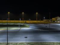 empty road with light at night with no cars on it and many lights over it