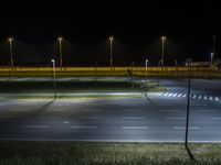 empty road with light at night with no cars on it and many lights over it