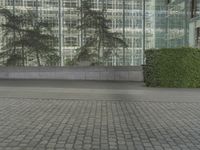 a person is skateboarding down a paved area next to tall buildings with lights in the sky