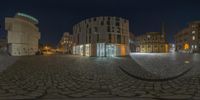 there is a fish eye lens that shows the streets in front of buildings at night