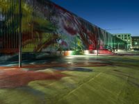 an empty parking lot in front of a building with brightly painted walls and stairs on it