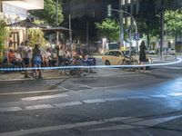 a crowd of people stand at a curb and wait for a car to cross the street