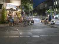 a crowd of people stand at a curb and wait for a car to cross the street