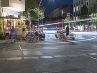 a crowd of people stand at a curb and wait for a car to cross the street