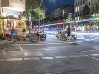 a crowd of people stand at a curb and wait for a car to cross the street