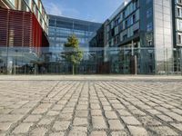 a brick pathway outside an office building with some red bricks on the side of it