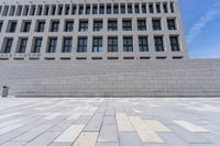 a stone floor in front of an office building with windows that says fedurm