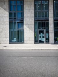 a couple of windows are on the building next to it's sidewalk with post it notes