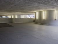 this image shows a circular empty room filled with concrete space and several doors opened in the corner