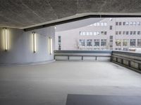 this image shows a circular empty room filled with concrete space and several doors opened in the corner