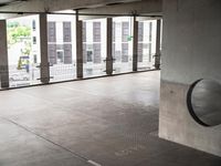 a round object is placed on a grating surface in a building with glass windows