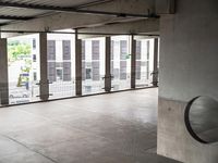 a round object is placed on a grating surface in a building with glass windows