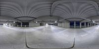 a fish - eye lens lens of an empty parking garage with a view of the ground outside