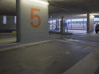 the parking garage is empty with cars in it at night with the number five painted on it