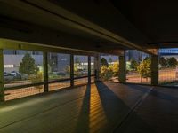 an empty parking garage with no windows at night, overlooking the airport walkways and cars