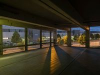 an empty parking garage with no windows at night, overlooking the airport walkways and cars