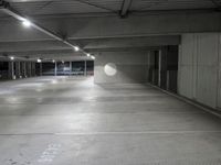 the empty parking garage of an underground building with a circular window in it's ceiling