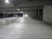 the empty parking garage of an underground building with a circular window in it's ceiling