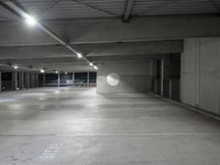 the empty parking garage of an underground building with a circular window in it's ceiling