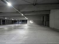 the empty parking garage of an underground building with a circular window in it's ceiling