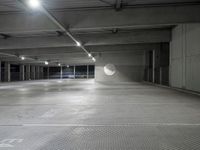 the empty parking garage of an underground building with a circular window in it's ceiling