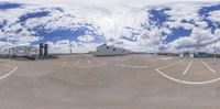 a view of a parking lot and some clouds in the sky from a fisheye lens