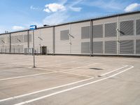 the view from a parking lot at a large warehouse building, and it looks to be empty