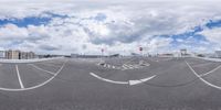 a 360 - lens view of a parking lot with an intersection and stop signs painted on the asphalt