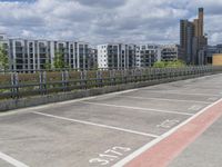 parking space at an apartment complex next to an overpass on a sunny day with city buildings